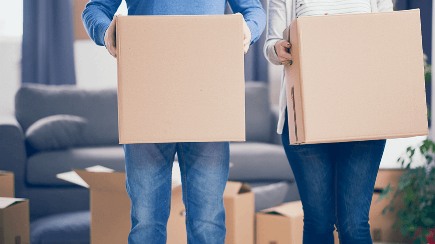 Couple qui porte des cartons de déménagement 